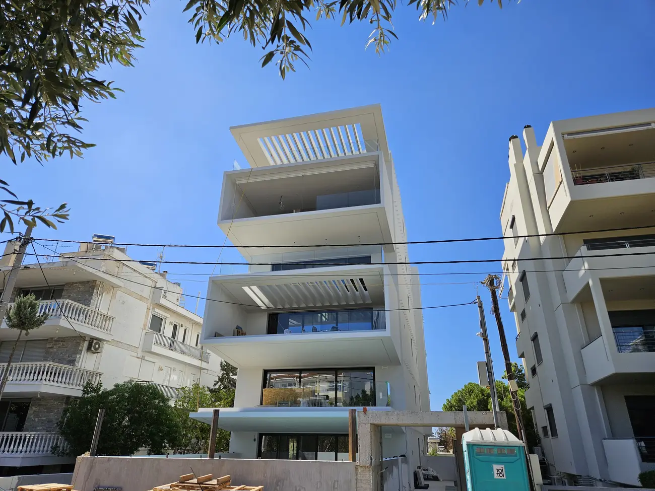 Σύγχρονη πενταώροφη λευκή πολυκατοικία minimal αρχιτεκτονικής με γεωμετρικά σχήματα