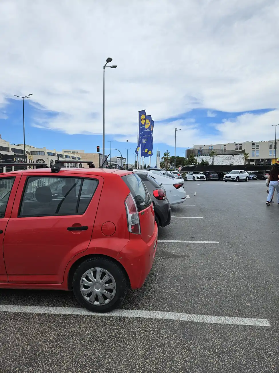 παίθριος χώρος στάθμευσης σούπερ μάρκετ στη Γλυφάδα με σειρά σταθμευμένων αυτοκινήτων